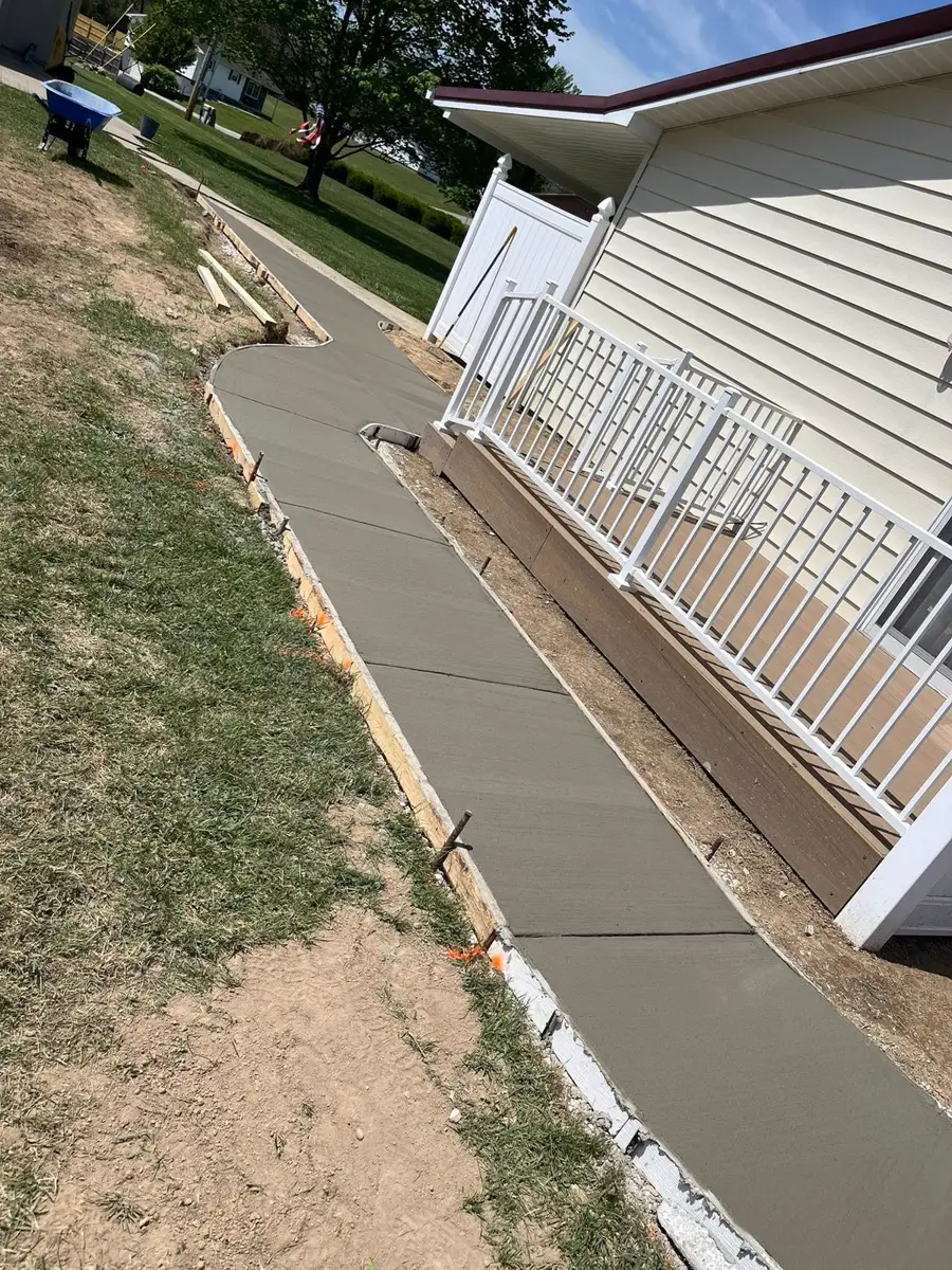New sidewalk along a house with white railing