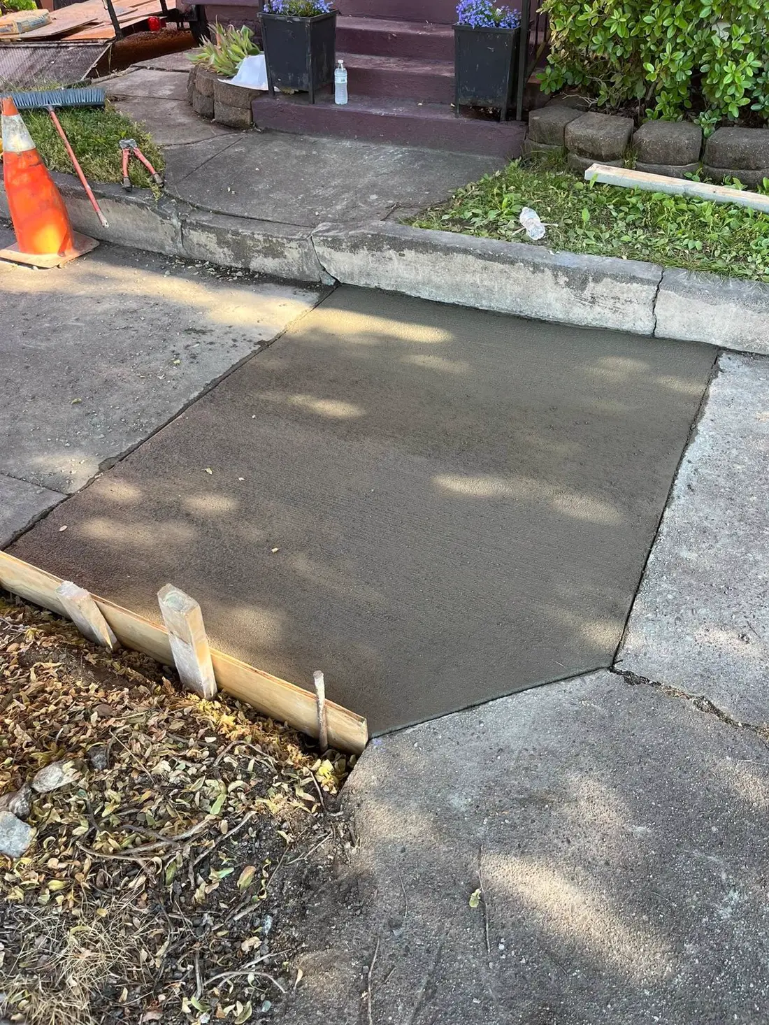 Fresh concrete replacement section poured into an existing drive