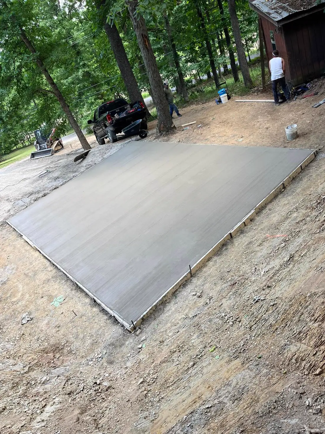 Fresh patio slab poured under shade trees